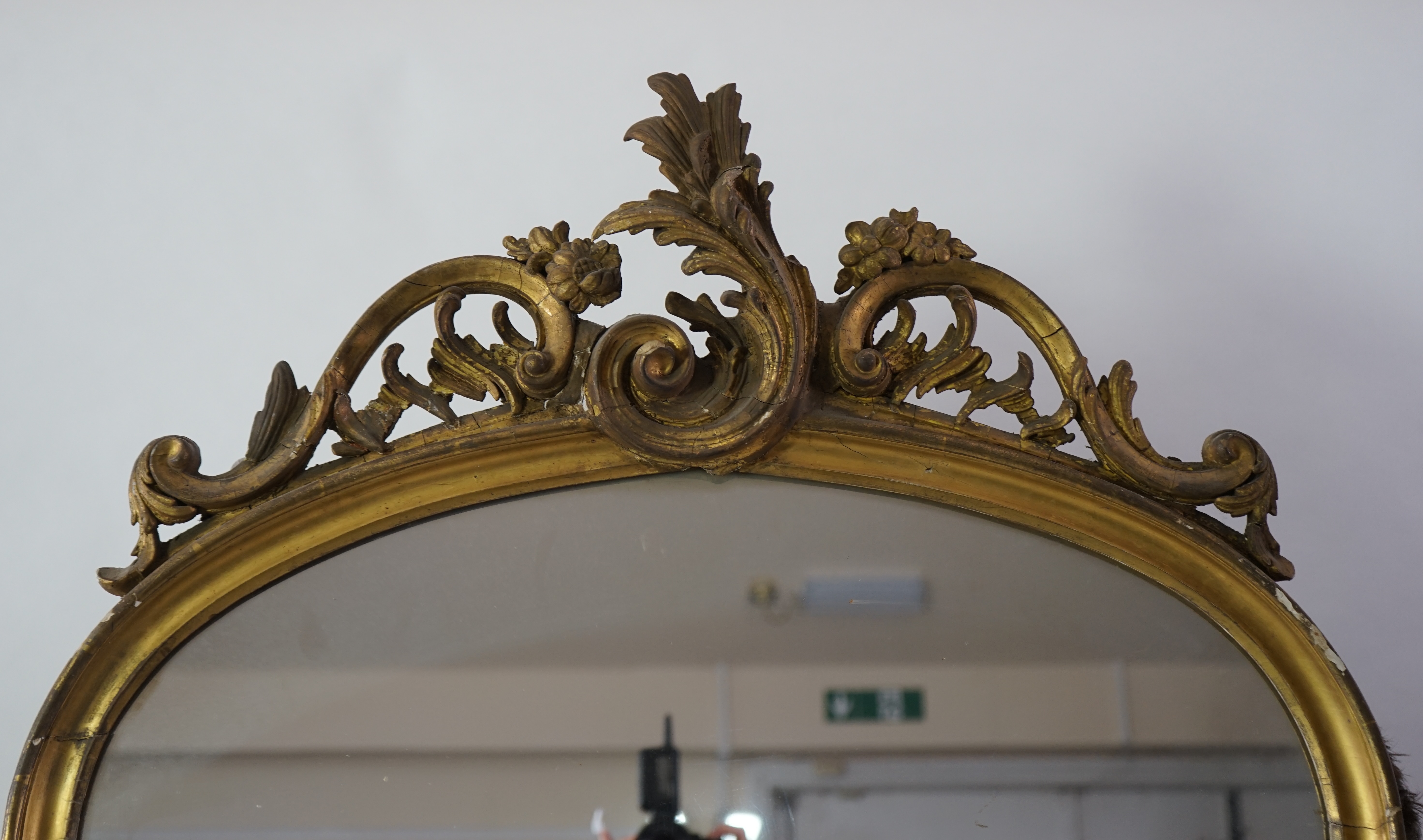 A pair of late 19th century giltwood and gesso pier glasses, with asymmetrical rococo scroll crests and arched plates, 80cm wide, 221cm high. Condition - fair